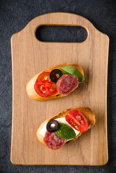 Open faced sandwich canape or crostini on a wooden serving board