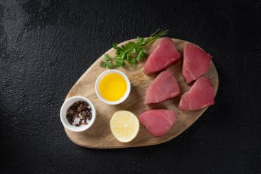 Siyah arka plan üzerine kurulu kesme üzerinde ton balığı. Yemek pişirmek için hazırlık