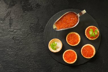 Tartlets siyah bir zemin üzerine kırmızı havyar