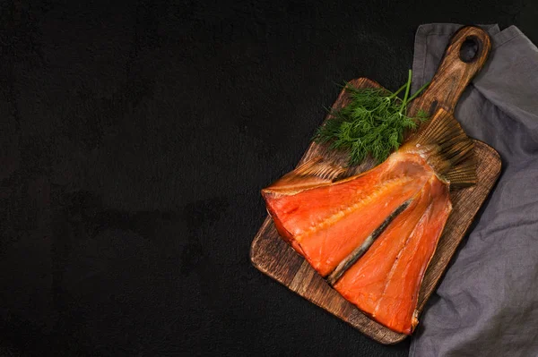 Smoked salmon tail on a black background