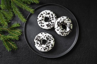 Çörek beyaz sır ve siyah arka plan üzerine çikolata ile