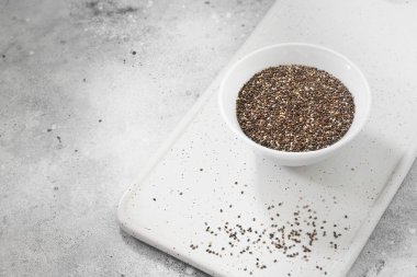 Sağlıklı beslenme için chia tohum. Beyaz bir kase içinde. Gri arka plan üzerinde