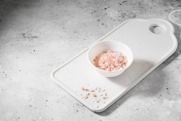 Pink sea salt on a light gray background