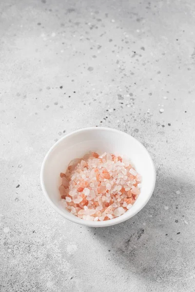 Pink sea salt on a light gray background