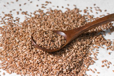 Gri bir tablo üzerinde dağınık keten tohumu. Organik gıda