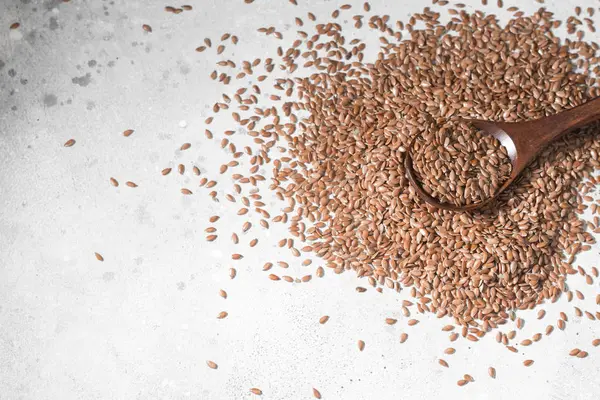 Gri bir tablo üzerinde dağınık keten tohumu. Organik gıda