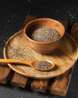 Chia tohum koyu arka plan üzerinde ahşap plaka. sağlıklı beslenme için organik gıda