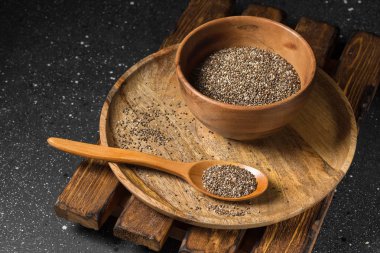 Chia tohum koyu arka plan üzerinde ahşap plaka. sağlıklı beslenme için organik gıda