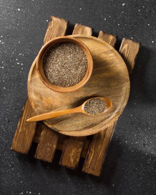 Chia tohum koyu arka plan üzerinde ahşap plaka. sağlıklı beslenme için organik gıda