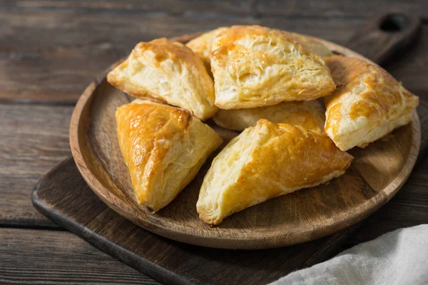 Ahşap bir masa üzerinde ahşap bir gemide puf çörekler. Hamur işi. Rustik tarzı