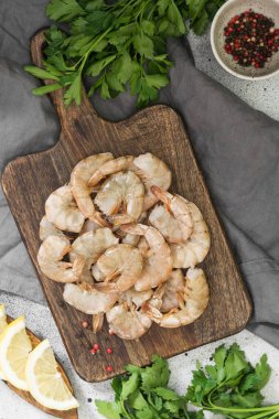 Gri arka plan üzerinde ahşap tahta üzerinde ham kaplan karides