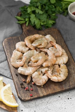 Gri arka plan üzerinde ahşap tahta üzerinde ham kaplan karides