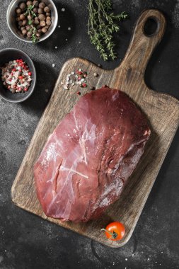 Çiğ Ren geyiği eti koyu arka plan üzerinde ahşap tahta üzerinde