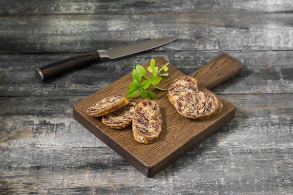 Smoked sausage on a wooden Board on a grey wooden table
