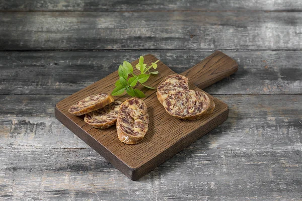 Smoked sausage on a wooden Board on a grey wooden table