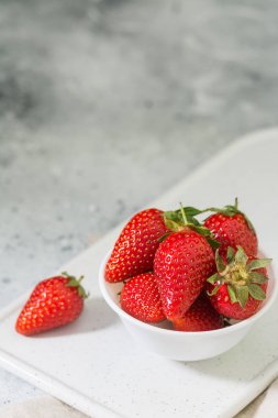 Açık arka planda beyaz tabakta çilek