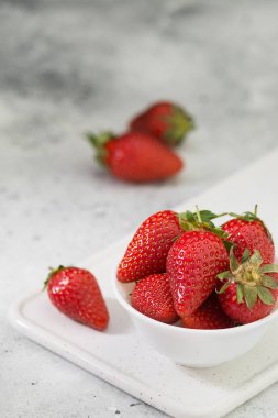 Açık arka planda beyaz tabakta çilek