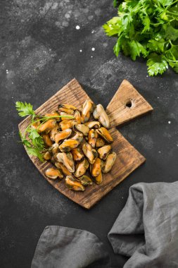 Koyu arkaplanda tahtadan yapılmış midye eti.