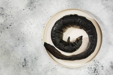 Beyaz tabakta, arka planda yılan balığı.