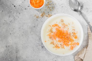 Hafif bir arka planda beyaz bir plaka içinde havuç ve ceviz ile irmik lapası