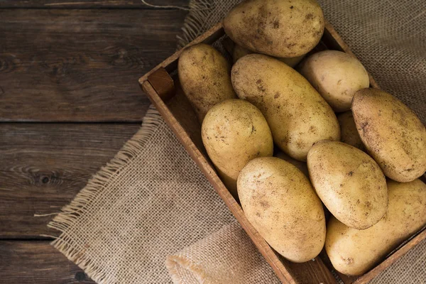 Ahşap masada bir kutuda patates. Rustik tarzı