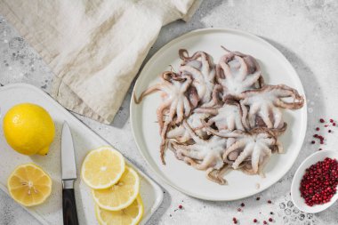 Hafif bir arka plan üzerinde beyaz bir tabak ta ham ahtapotlar