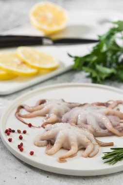 Hafif bir arka plan üzerinde beyaz bir tabak ta ham ahtapotlar