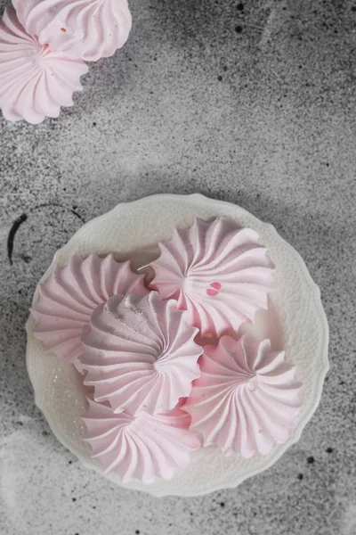 Pink meringue. French dessert. On the grey table