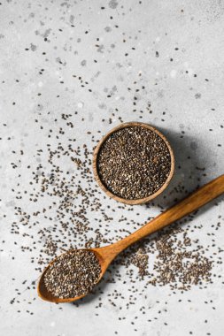 Chia tohumları ahşap bir kapta hafif bir arka plan üzerinde. Sağlıklı beslenme için