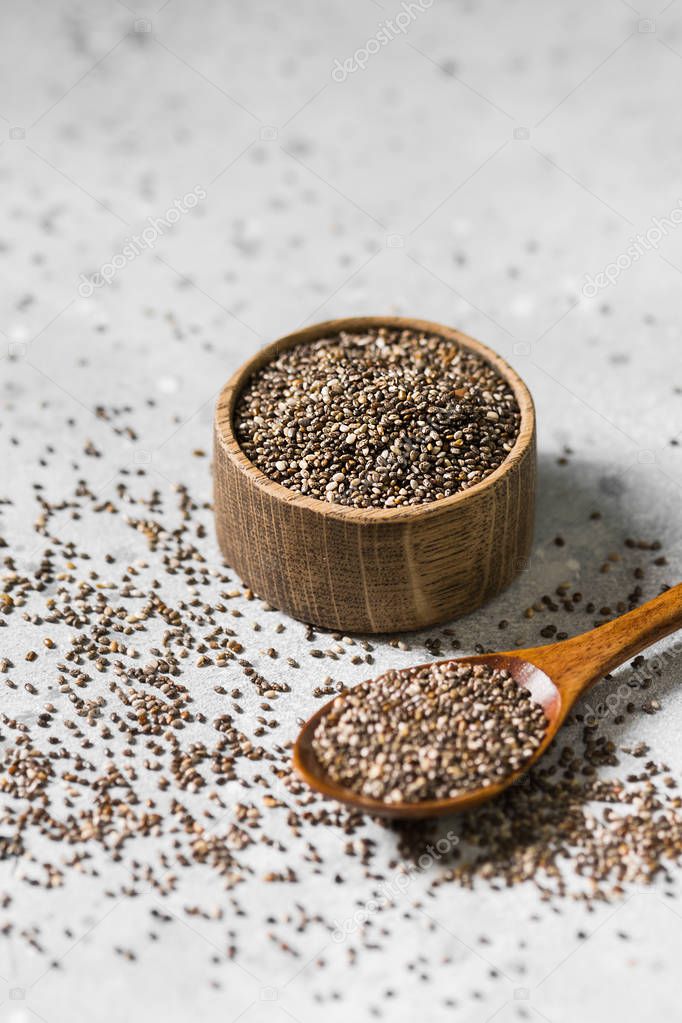 Chia seeds in a wooden bowl on a light background. For healthy nutrition