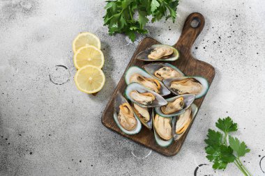 Gri bir arka plan üzerinde ahşap bir Tahta üzerinde Kivi midye. Sağlıklı beslenme