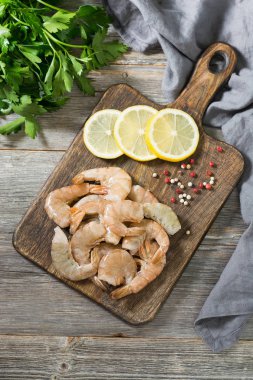 Tahta üzerinde kaplan karidesleri. Gri arka plan. Deniz ürünleri.