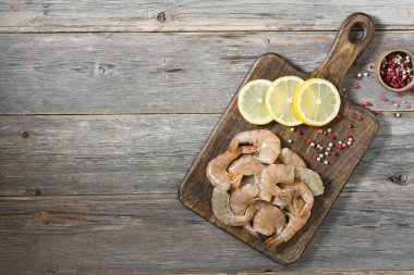 Tahta üzerinde kaplan karidesleri. Gri arka plan. Deniz ürünleri.