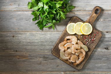 Tahta üzerinde kaplan karidesleri. Gri arka plan. Deniz ürünleri.