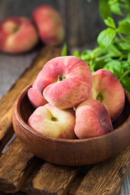 Tahta bir kasede incir şeftalisi. Düz şeftali