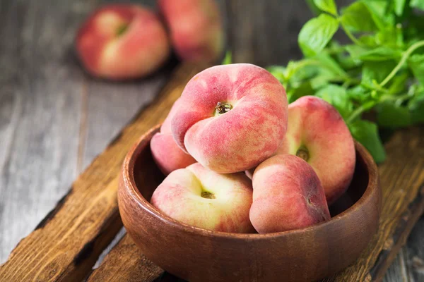 Tahta bir kasede incir şeftalisi. Düz şeftali