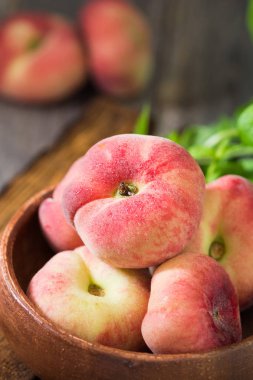 Tahta bir kasede incir şeftalisi. Düz şeftali