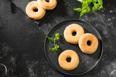 Çörekler şeker serpilir. Koyu arka plan