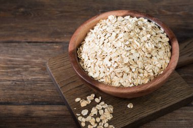 Ahşap bir masada bir ahşap kase yulaf ezmesi