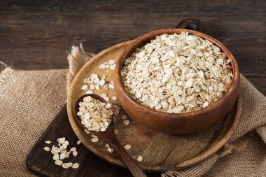 Ahşap bir masada bir ahşap kase yulaf ezmesi