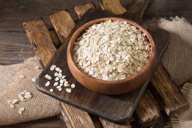 Ahşap bir masada bir ahşap kase yulaf ezmesi