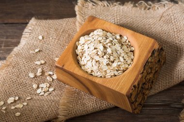 Ahşap bir masada bir ahşap kase yulaf ezmesi