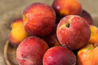 Ahşap bir masa üzerinde ahşap bir tabak üzerinde Şeftali. Rustik stil