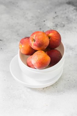 Hafif bir arka plan üzerinde beyaz tabaklarda Şeftali
