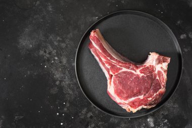 Siyah tabakta çiğ sığır eti. Koyu arka plan