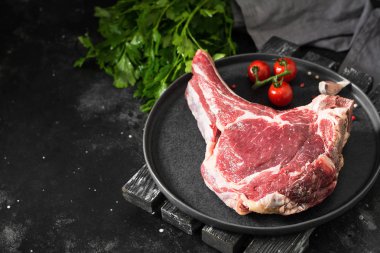 Siyah tabakta çiğ sığır eti. Koyu arka plan