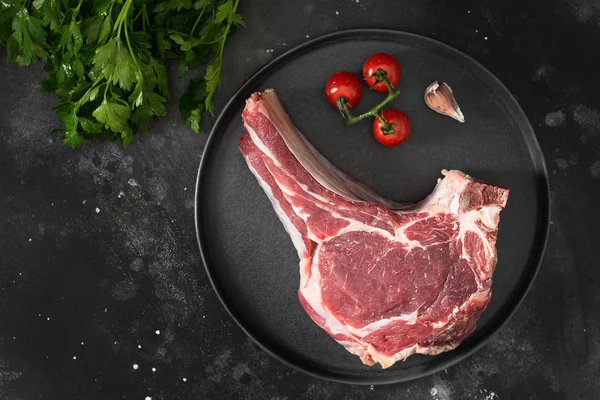 Siyah tabakta çiğ sığır eti. Koyu arka plan