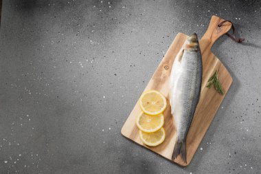 Gri bir arka plan üzerinde doğrama Tahtası üzerinde çiğ balık. Uskumru.