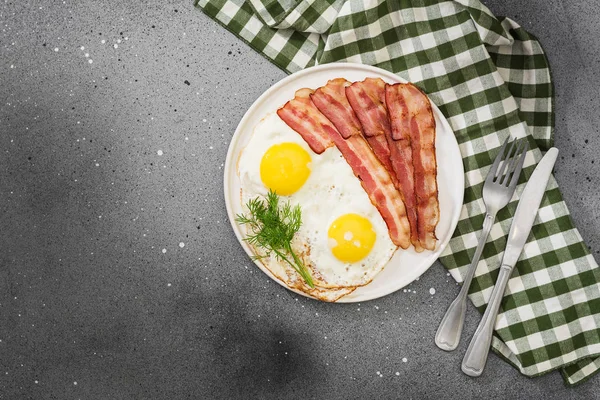 Яичница Беконом Белой Тарелке Сером Столе Завтрак — стоковое фото