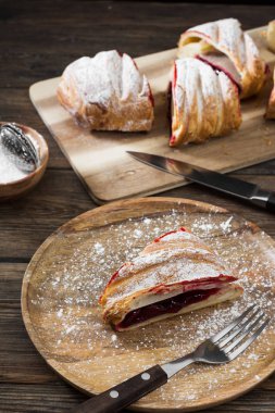 Ahşap arka plan üzerinde kiraz ile Strudel. Rustik stil